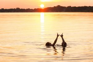 Students in lake making a W with their hands