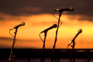 Four microphones against a sunset backdrop