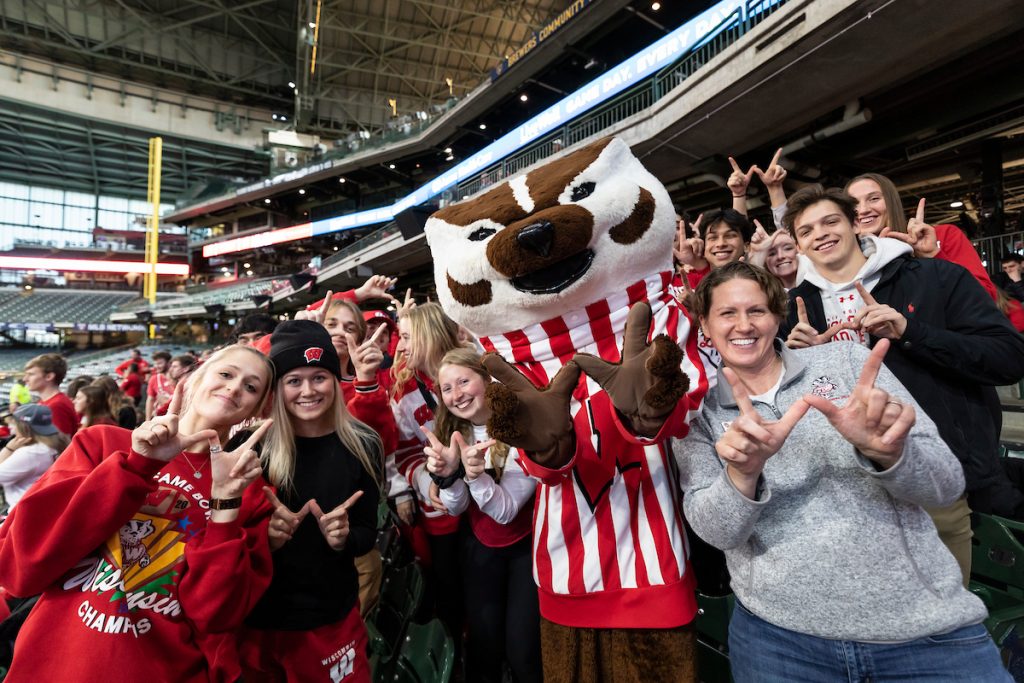 Christina Olstad (far right), dean of students, pose with Badger fans in the student section