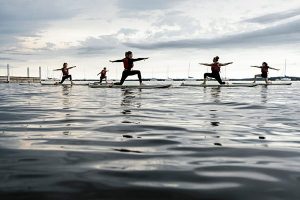 Students participating in a SUP class on the lake