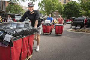 Student pushing red cart during move-in