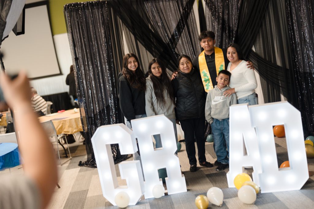 A family of different ages celebrates their graduate with a group picture at the photo booth hosted by Clarissa Friday Photography.