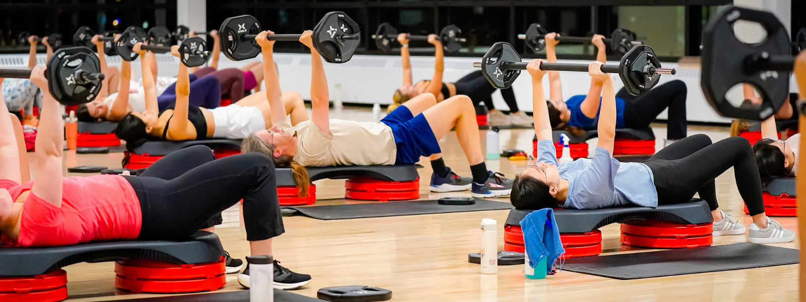 A group fitness class in session lifting weights