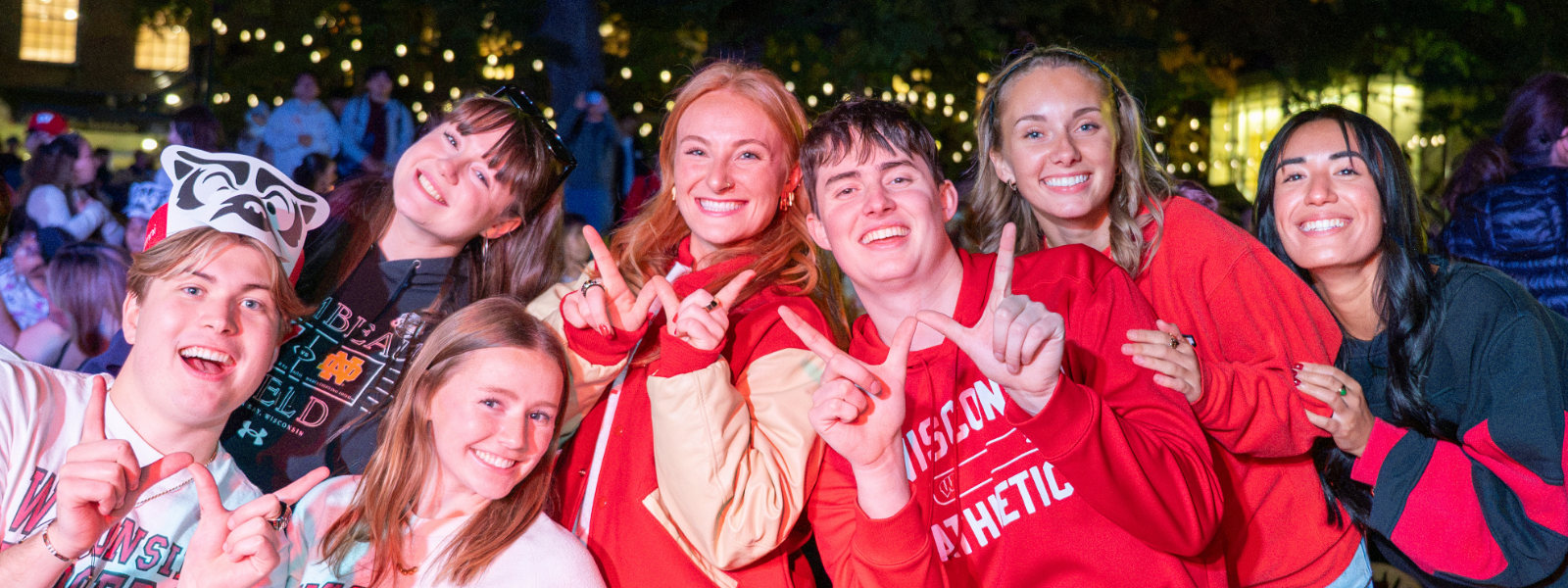 Group of University of Wisconsin students holding up their hands to create the shape of a W with their fingers.