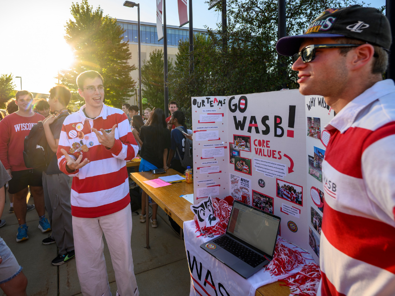 Two students stand next to their table about WASB at the Student Org Fair