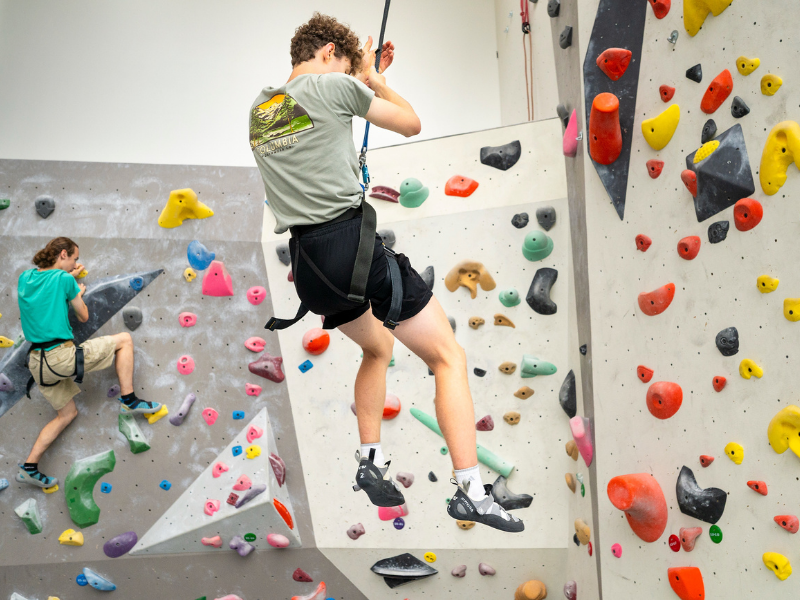 Students climb the rock wall at the Bakke 
