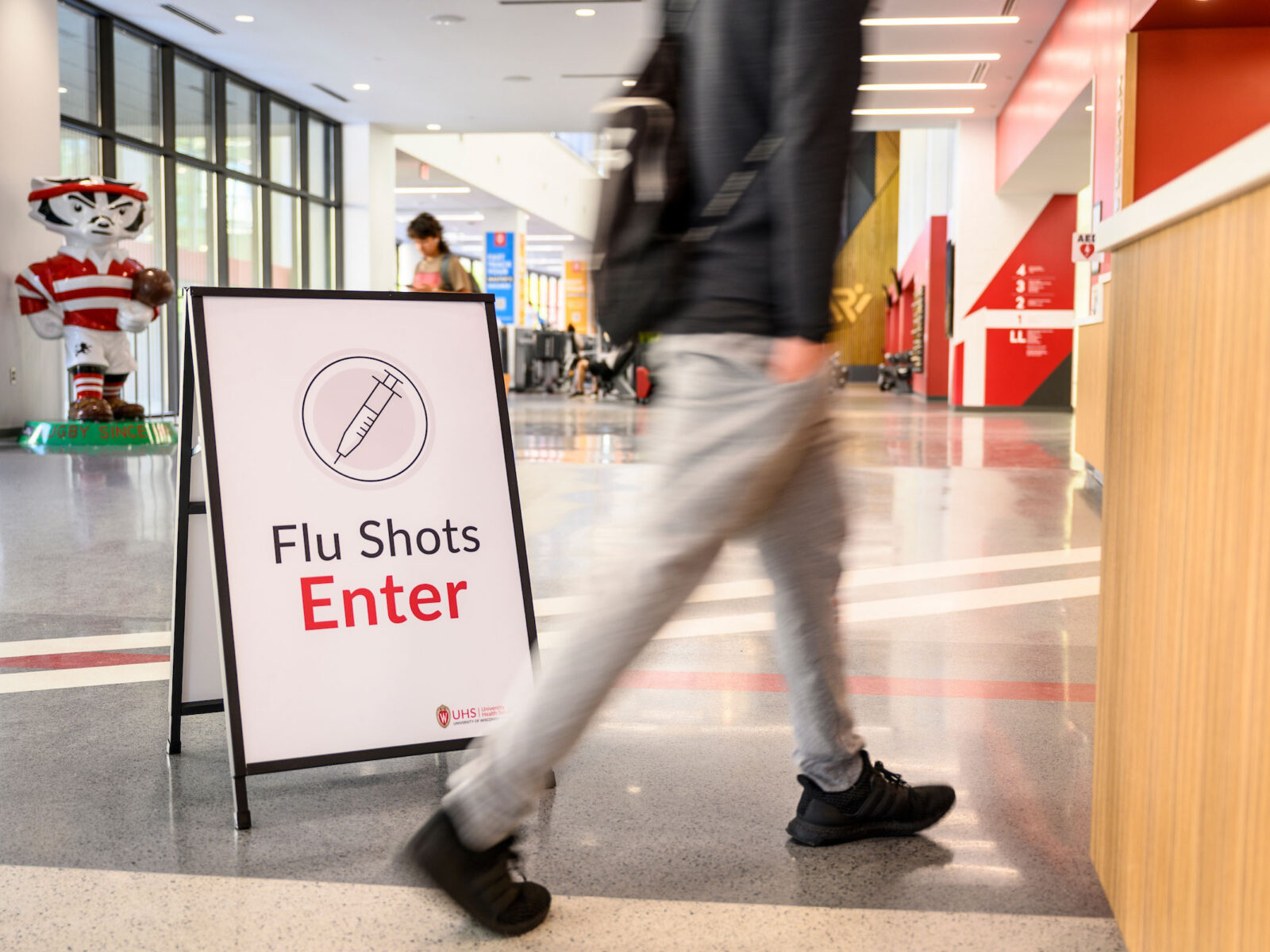A student walks past a sign at the entrance to a flu vaccine clinic